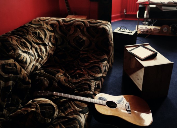 Guitarra apoyada en sofa