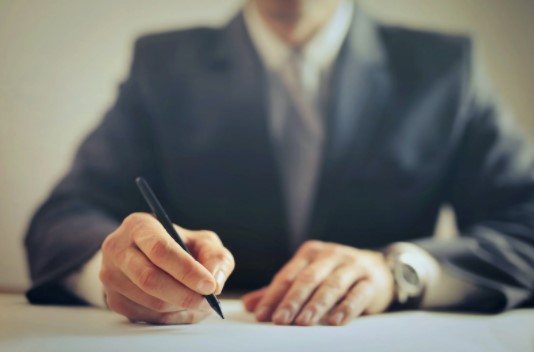hombre de traje firmando