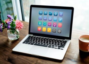 Air mac sobre mesa con flores y cafe