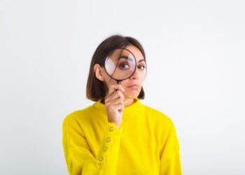 Mujer con lupa sobre ojo