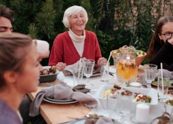 Mujer mayor disfrutando de comida en familia