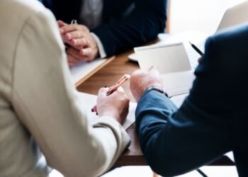 Personas arreglando papeleos ante notario
